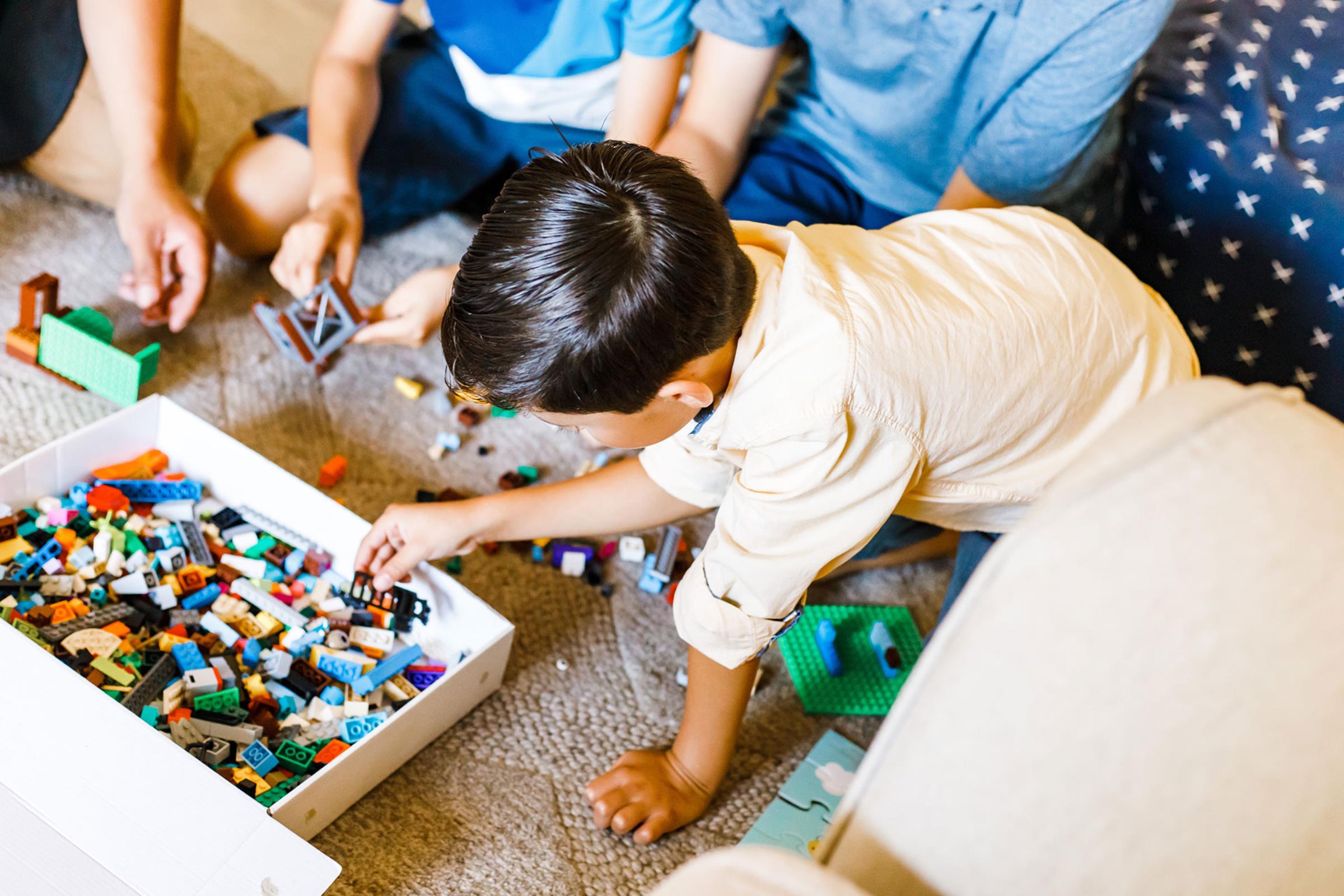 Male child playing with Legos on the floor